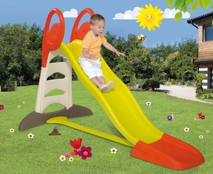 Enfant en mouvement autour d'un grand toboggan de jardin